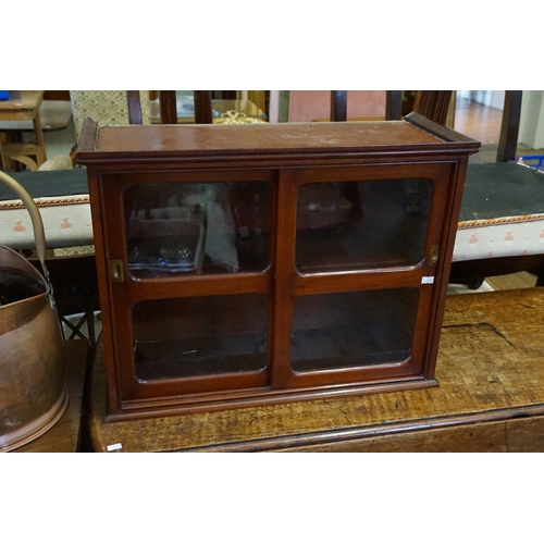 525 - A Mahogany Double Sliding Doored Glass Cabinet. Measuring: 61cms across x 47cms high x 25cms deep.