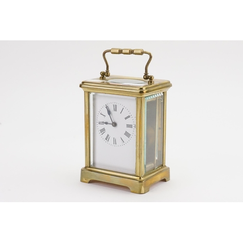 232 - A French cased Carriage Clock with enamelled Face, Black Roman numerals, carrying Handle & Key.