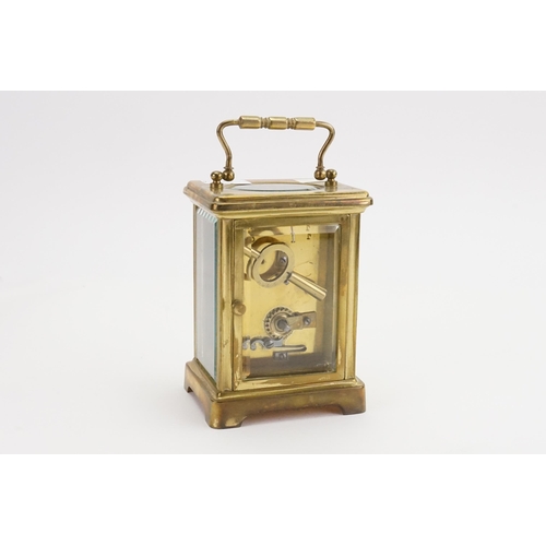 232 - A French cased Carriage Clock with enamelled Face, Black Roman numerals, carrying Handle & Key.