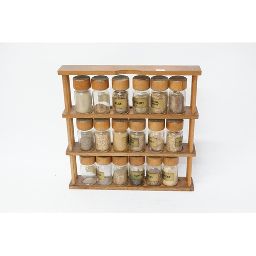 762 - A wooden spice rack, with glass jars filled with spices.