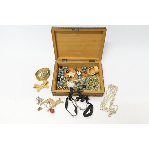 194 - A collection of costume jewellery to include beads, bangle, shell necklaces etc, contained in a wood... 