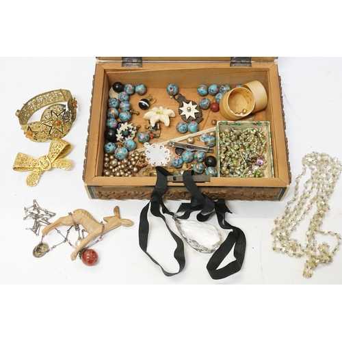 194 - A collection of costume jewellery to include beads, bangle, shell necklaces etc, contained in a wood... 