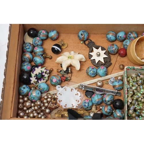 194 - A collection of costume jewellery to include beads, bangle, shell necklaces etc, contained in a wood... 