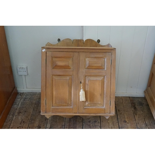 581 - A Panelled Pine Corner Cabinet. Measuring: 55cms across x 67cms high x 39cms deep.