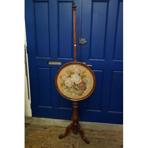 604 - A Victorian Mahogany Pole Screen resting on a Tripod Base with an inset neddlework of Flowers. Measu... 