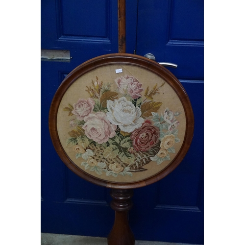 604 - A Victorian Mahogany Pole Screen resting on a Tripod Base with an inset neddlework of Flowers. Measu... 