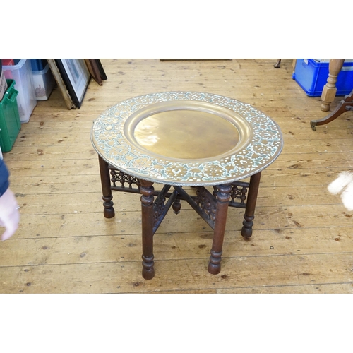 533 - A Large Persian embossed Tiffin Table in Brass with a Folding Hardwood Stand. Measuring: 76cms acros... 