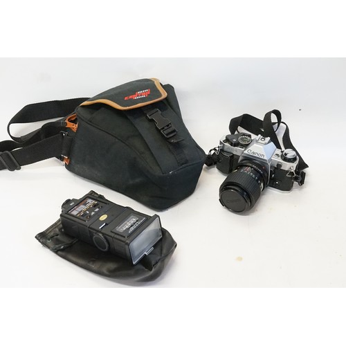 883 - A Canon AE1 Camera with Lens & Flash in a Centon Bag.