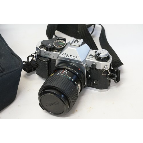 883 - A Canon AE1 Camera with Lens & Flash in a Centon Bag.