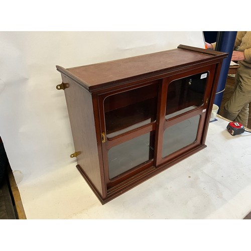 525 - A Mahogany Double Sliding Doored Glass Cabinet. Measuring: 61cms across x 47cms high x 25cms deep.