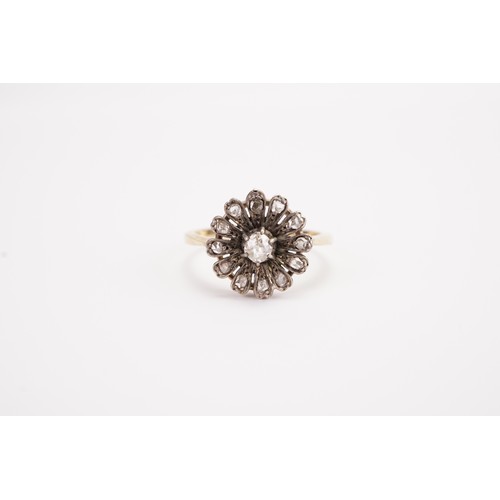 138 - A 18ct gold diamond set floral ring, set with a 0.15ct old mine cut diamond, surrounded by 12 chip d... 