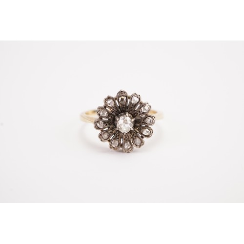 138 - A 18ct gold diamond set floral ring, set with a 0.15ct old mine cut diamond, surrounded by 12 chip d... 