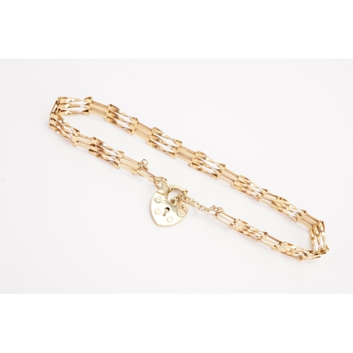 128 - A 9ct gold gate bracelet, hung with a love heart locket. Weight 3.4g.