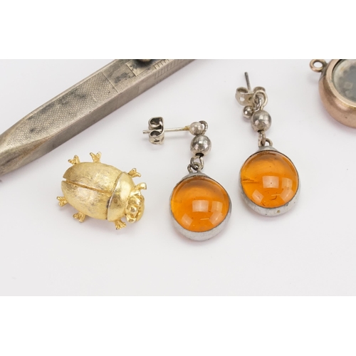 177 - A pair of amber coloured earrings, along with a miniature dice shaker, silver pencil, and a beetle.