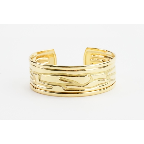 92 - A 18ct gold wide wrist cuff, with indented design. Weight 27g.