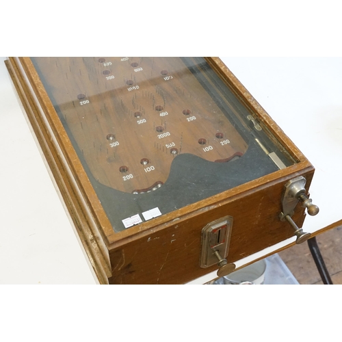 850 - An Early 20th Century Table Top Bagatelle Game in oak case with glazed top and coin operated mechani... 