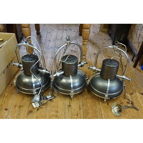 562 - A Set of Three Industrial Chrome & Grey Ceiling Lamps. Measuring: 57cms high x 40cms across.