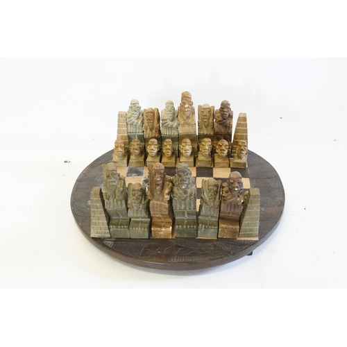 698 - An African Carved Chess Set with Native Figures & a Chess Board to match.