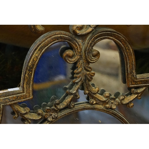 541 - A metal framed mirror, in floral scroll decoration. Measuring 127cm high x 80cm wide.