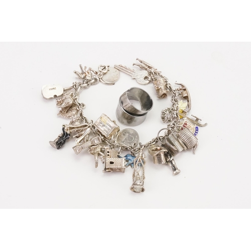 165 - A silver charm bracelet to include elephant and tiger charms (66.8g), along with two unmarked rings.