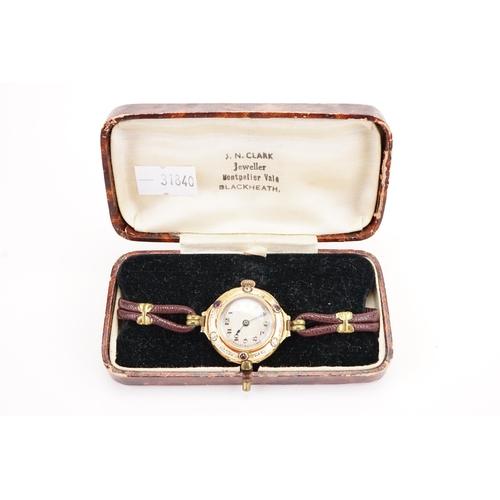 180 - A 18ct gold diamond and amethyst set wrist watch, Greek key white and red enamel design, brown leath... 