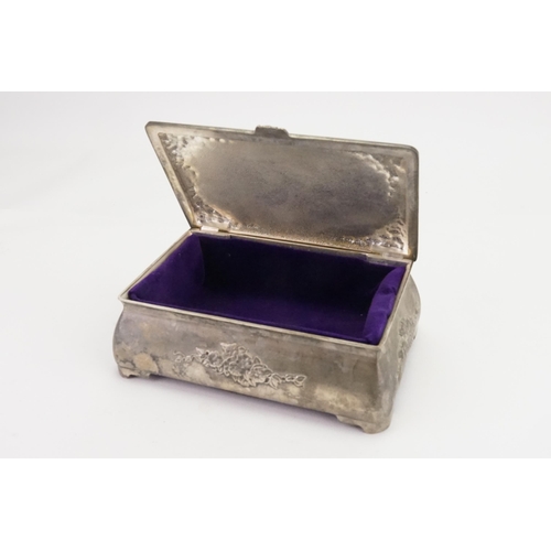 706 - A floral embossed pewter jewellery box, in the Liberty design, inlaid with purple.