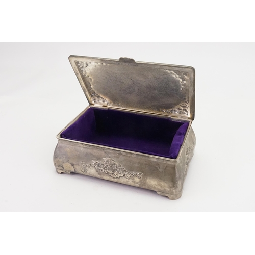 706 - A floral embossed pewter jewellery box, in the Liberty design, inlaid with purple.