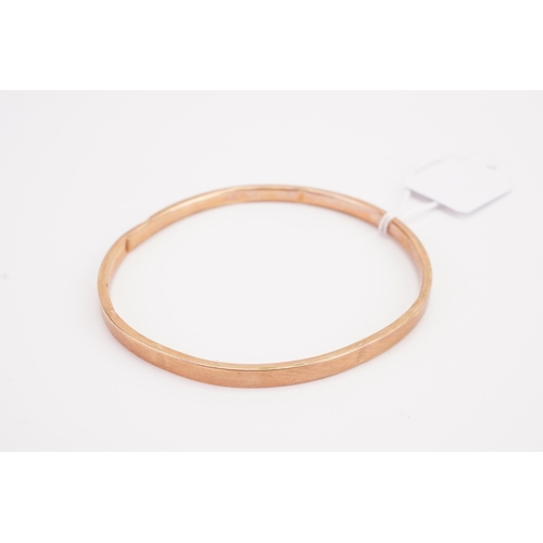 127 - A 9ct gold bangle, with arrow design. AF. Weight 7.3g.