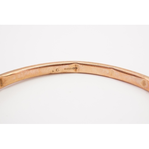 127 - A 9ct gold bangle, with arrow design. AF. Weight 7.3g.