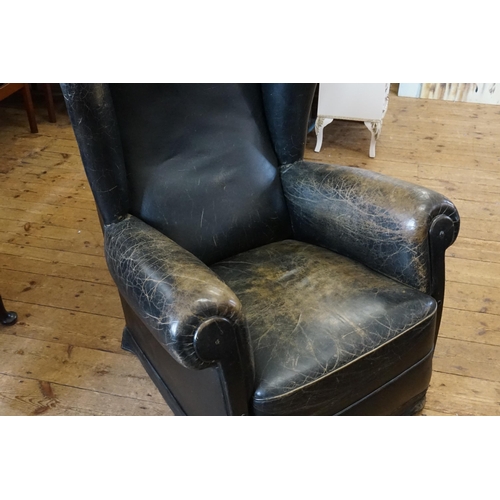 500 - A Leather Semi-Winged Fireside Chair with Roll Over Arms in Black.