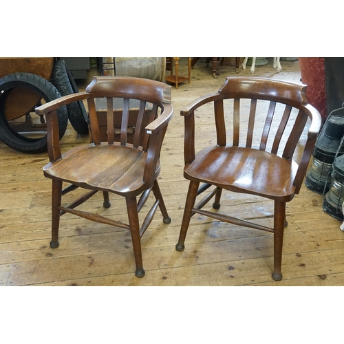 513 - A Pair of Arts & Crafts Oak Bow Back & Splat Elbow Chairs resting on Turned Legs & Cross Stretchers.