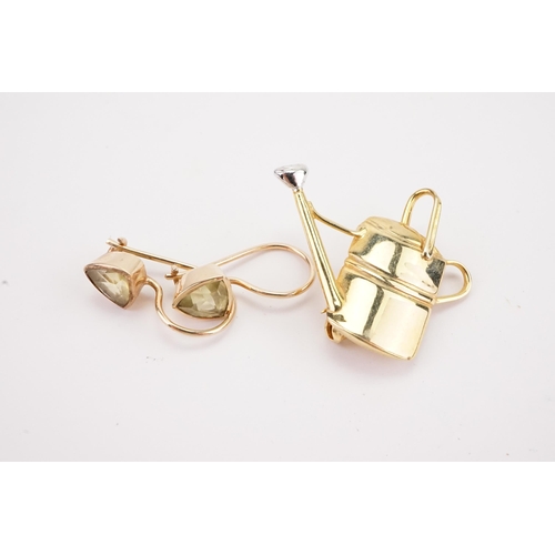 101 - A pair of 9ct gold peridot set earrings, along with a 9ct gold watering can. Weight 6.2g.