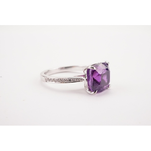 108 - A natural purple sapphire and diamond set ring, set with a East African translucent natural purple s... 