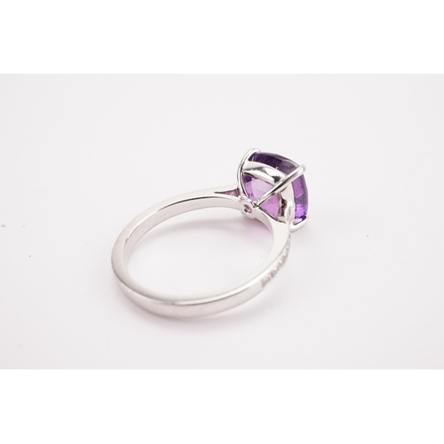 108 - A natural purple sapphire and diamond set ring, set with a East African translucent natural purple s... 