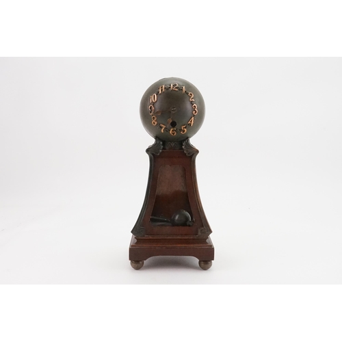 173 - An Art Nouveau Globe Shaped Mantle Clock with Bronze Corners. Standing: 30cms high.