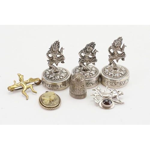 76 - A set of three silver coloured white metal place holders, along with a thimble etc.