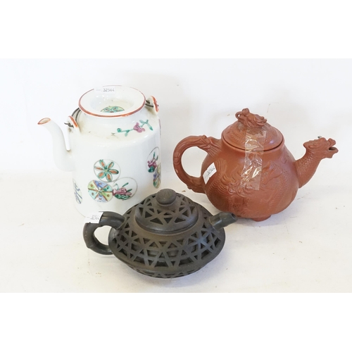 560 - A Yixing moulded Tea Pot, a Black Glazed reticulated Tea Pot with Seal & a Chinese Kettle.