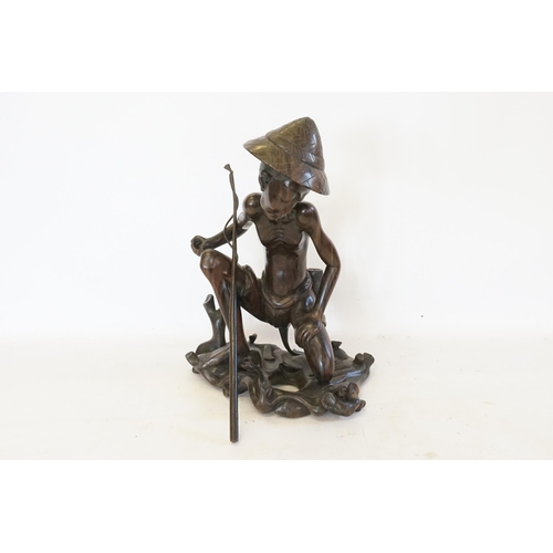 708 - A Carved Balinese Study of a Fisherman. (AF). Measuring: 41cms.