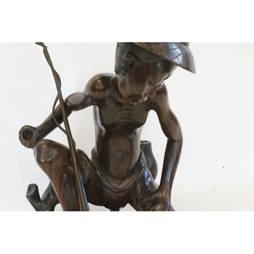 708 - A Carved Balinese Study of a Fisherman. (AF). Measuring: 41cms.