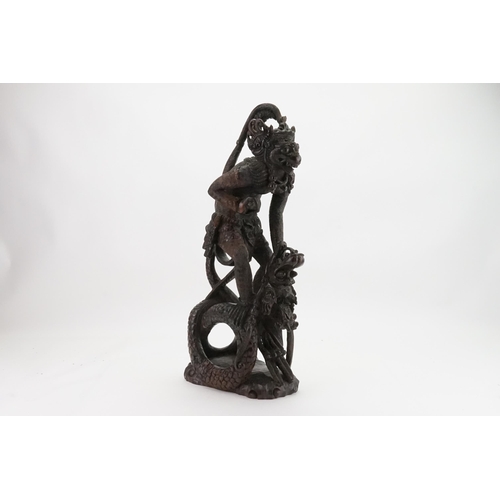 709 - A Carved Hardwood Study of the Monkey God Killing the Dragon. Measuring: 55cms High.