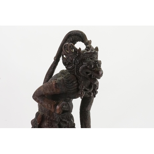 709 - A Carved Hardwood Study of the Monkey God Killing the Dragon. Measuring: 55cms High.