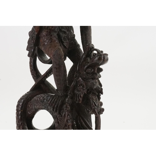 709 - A Carved Hardwood Study of the Monkey God Killing the Dragon. Measuring: 55cms High.