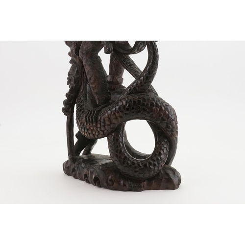 709 - A Carved Hardwood Study of the Monkey God Killing the Dragon. Measuring: 55cms High.