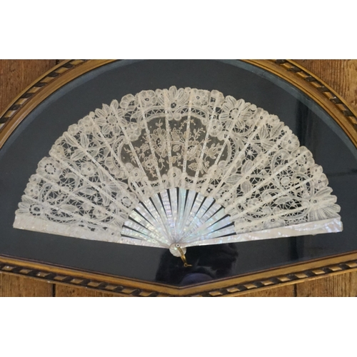 712 - A Victorian Mother of Pearl Fan contained in a Glass Fronted Fan Shaped Frame.