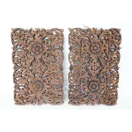 517 - A pair of circa 1930's carved wooden panels, depicting flowers. Measuring: 45cms x 29.5cms.