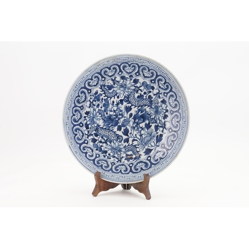 566 - A Chinese Blue & White charger decorated with two dragons. Measuring: 30cms.