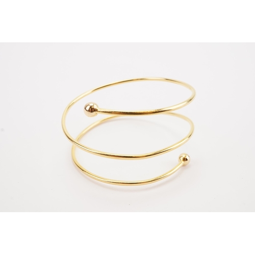 114 - Ex Collection of Mariam Jans Daughter. A high carat gold spiral arm bangle. Weight 26.8g. (No. 15) D... 