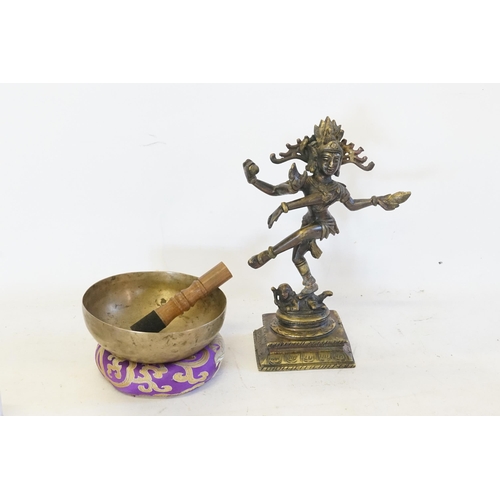 533 - An Indian Bronze of Lord Krishna, with four hands. Height 25cm. Along with a singing bowl etc.