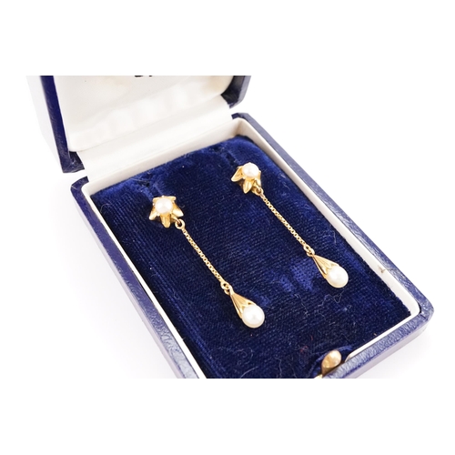 152 - A pair of unmarked pearl set drop earrings. Studs designed as stars. Weight 5.1g.