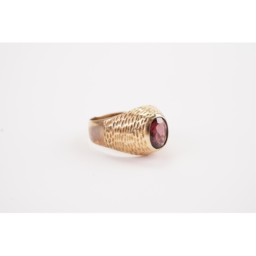 155 - A garnet set signet ring, the garnet is set in a unmarked raised setting. Size V. Approximate size o... 